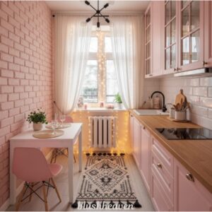 Charming pink kitchen with wood countertops, pink cabinets, and a cozy dining area with a white table. Fairy lights decorate the window, adding warmth.
