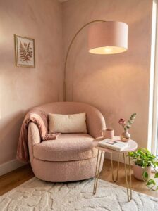 Cozy small apartment reading corner ideas featuring a beige boucle accent chair, round marble side table, gold floor lamp, and neutral rug.