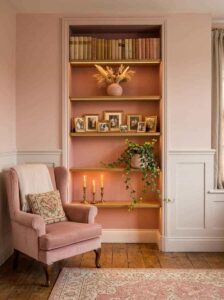 Floating bedroom alcove display shelves illuminated by hidden warm LED strip accent lighting highlighting books, candles, and plants.