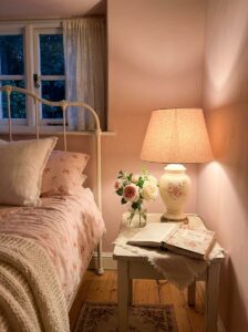 Elegant boutique hotel bedroom setup showing matching bedside table lamps with soft fabric shades diffusing a warm ambient glow.